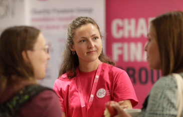 Image shows CFG staff Zoe Bennett standing and talking with two CFG members at the annual conference